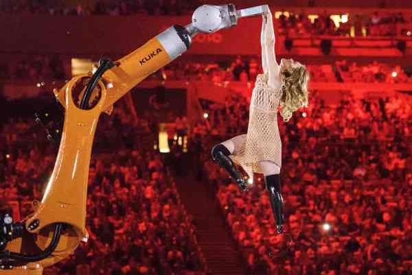 American Paralympic snowboarder Amy Purdy dances with a robot during the opening ceremony of the Rio 2016 Paralympic Games at the Maracana stadium in Rio de Janeiro on September 7, 2016. / AFP PHOTO / YASUYOSHI CHIBA